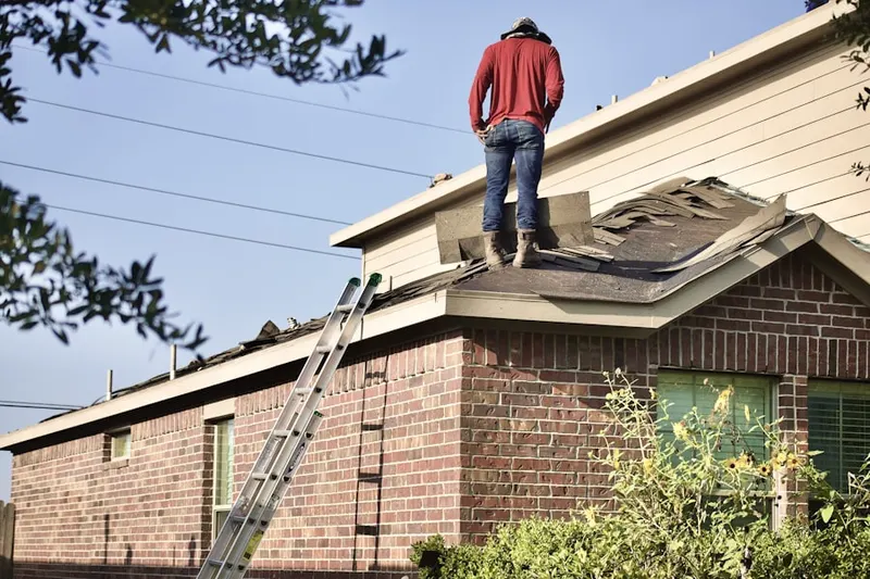 Professional roofer working on a residential roof in Seventy-First